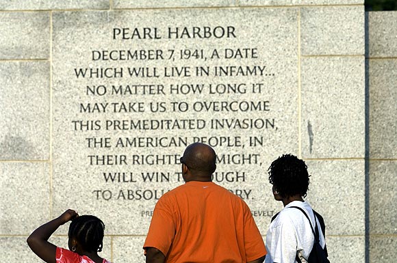 A family reads an inscription by President Franklin Delano Roosevelt on the bombing of Pearl Harbour