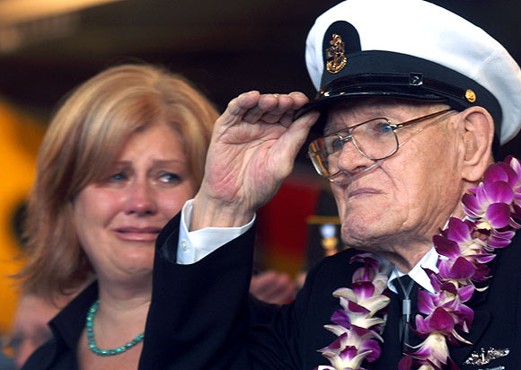 Lois Deininger of San Francisco watches her father, Pearl Harbor survivor, Edward Gaulrapp of Freeport Illinois, salute during the commemoration marking the 66th anniversary of Pearl Harbour attack