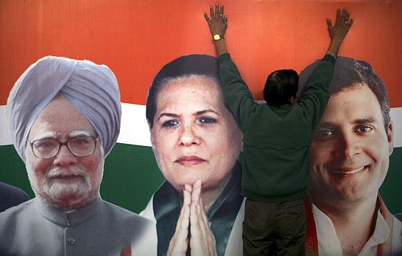 A worker installs a hoarding of the Congress party
