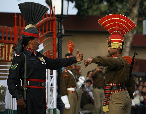 Pakistani Ranger and Indian Border Security Force soldiers gesture during a daily parade at the Pakistan-India joint check post at Wagh border, on the outskirts of Lahore
