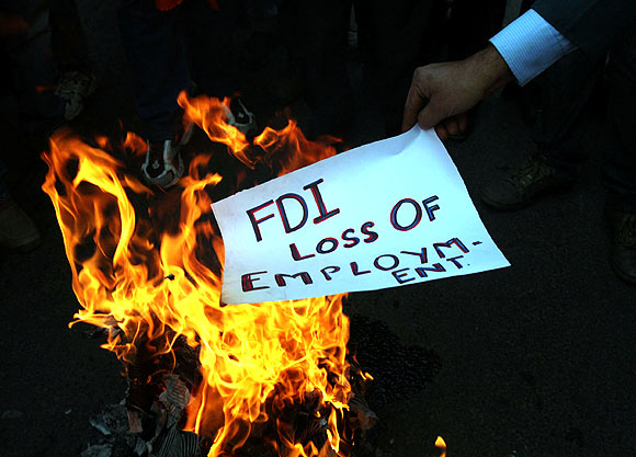 An activist of Shiv Sena burns a pamphlet during a protest against FDI in retail sector, in Jammu on November 30