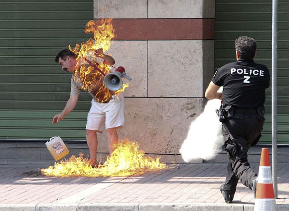 A man sets himself on fire outside a bank branch in Thessaloniki in northern Greece September 16, 2011. The 55-year old man had entered the bank and asked for a renegotiation of his overdue loan payments on his home and business, according to police, which he could not pay, but was refused by the bank