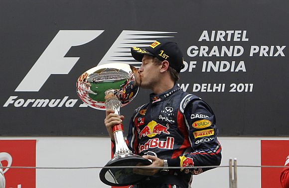 Red Bull Formula One driver Vettel kisses his trophy after winning the first Indian F1 Grand Prix at the Buddh International Circuit in Greater Noida