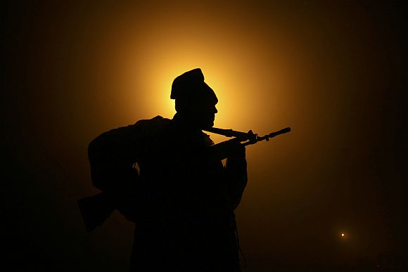A BSF soldier patrols near fencing at India-Pakistan border at Suchetgarh near Jammu