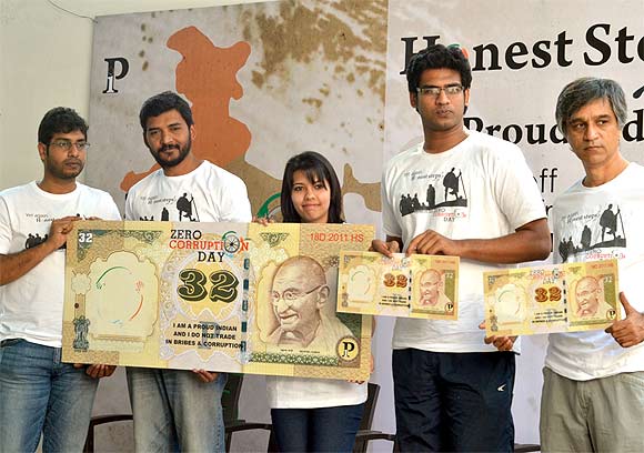 Members of 'Proud Indians' display a Rs 32 note symbolising the limit of their per day expenditure during the walkathon