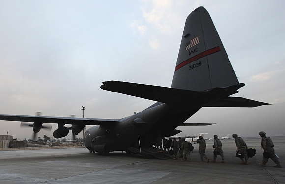 Members of the US military board an Air Force C-130 transport plane to leave Iraq at the Baghdad Diplomatic Support Center in Baghdad
