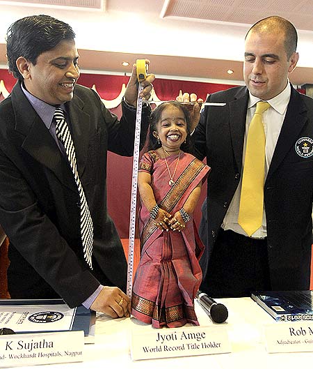 The Guinness World Records adjudicator Rob Molloy (R) and Indian doctor K. Sujatha (L) measure the height of Jyoti Amge, the world's shortest living woman