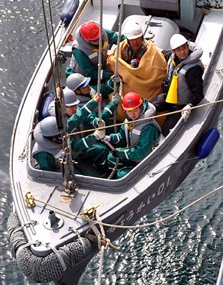 Shinkawa, who was swept out to sea by the tsunami, is rescued by crew members of Japan Maritime Self-Defence Force