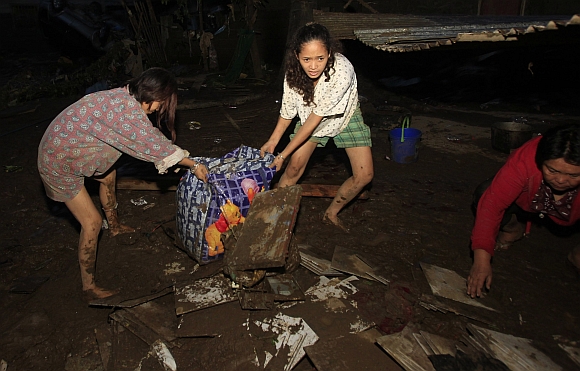 Residents retrieve belongings in Balulang village after the village was hit by flashfloods