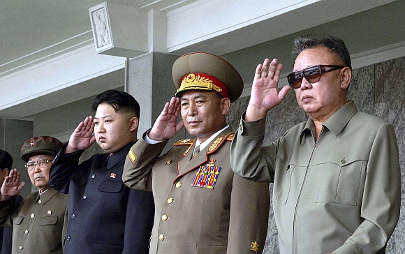 Kim Jong-il (right) and his son Kim Jong Un (third from right) salute as they watch soldiers attending a military parade in the Kim Il Sung square in Pyongyang in this September 9 photo