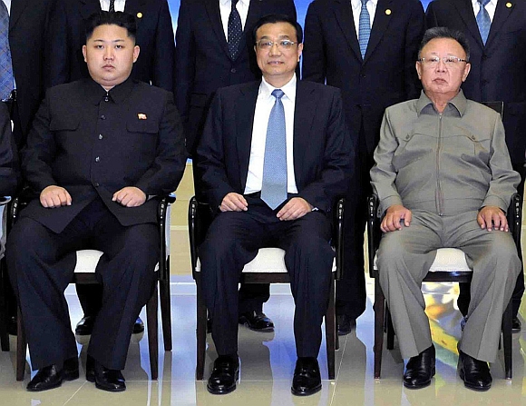 Kim Jong-Un and Kim Jong-il pose for photographs with the visiting Chinese Vice Premier Li Keqiang during their meeting in Pyongyang on October 24