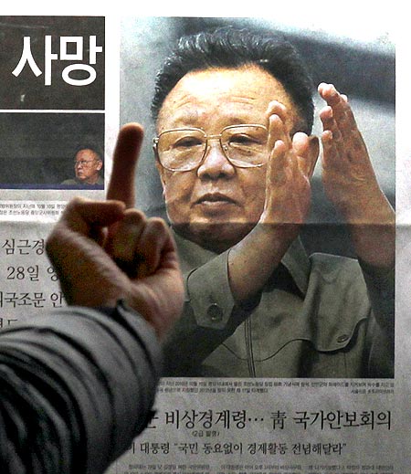 A picture of North Korean leader Kim Jong-il as he reads the report of his death on the newspaper company's display board in Seoul