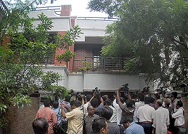Television cameramen fight for space outside the residence of Sadiq Basha, an associate of A Raja