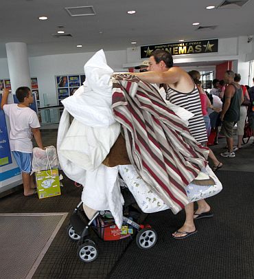 A man wheels bedding into an emergency cyclone shelter at a shopping mall