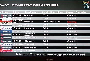 A flight information screen shows all flights cancelled except one at the Cairns airport
