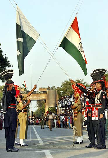 Pakistani Rangers and Indian Border Security Force lower their respective country flags during the daily parade at the Pakistan-India joint check-post at Wagah border
