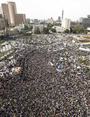 Opposition supporters gather and listen to Egyptian-born cleric Sheikh Yusuf al-Qaradawi, who says President Hosni Mubarak must stand down and leave Egypt, before Friday prayers at Tahrir Square