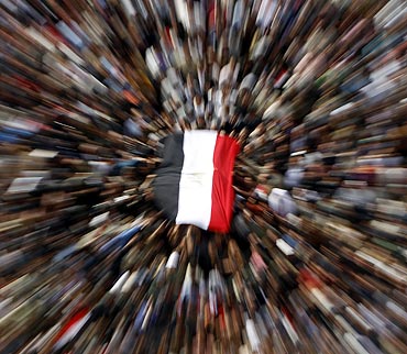 Anti-government demonstrators with an Egyptian flag shout anti-Mubarak slogans after Friday prayers at Tahrir Square in Cairo