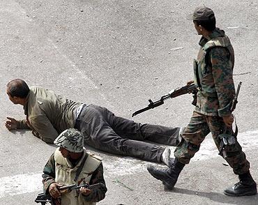 An Egyptian army member stops a pro-Mubarak supporter from speaking about Egyptian President Hosni Mubarak