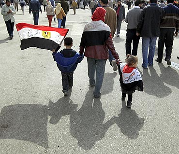 An opposition supporter walks with children to Friday prayers in Tahrir Square in Cairo