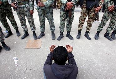 An opposition demonstrator prays in front of army soldiers near Tahrir Square in Cairo