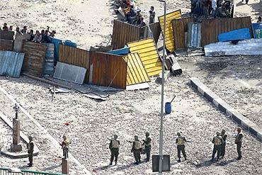 gyptian army soldiers stand in front of barricaded anti-government protesters during clashes with pro-government protesters in Tahrir square in Cairo