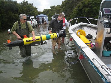 Dan Fornari (left) and Robin Littlefield, of Woods Hole Oceanographic Institution, load a REMUS autonomous underwater vehicle onto a support boat prior to launching the AUV on an eight-hour mapping and data capture mission