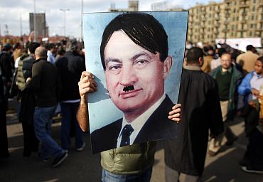 A protestor carries a picture depicting Mubarak as Adolf Hitler