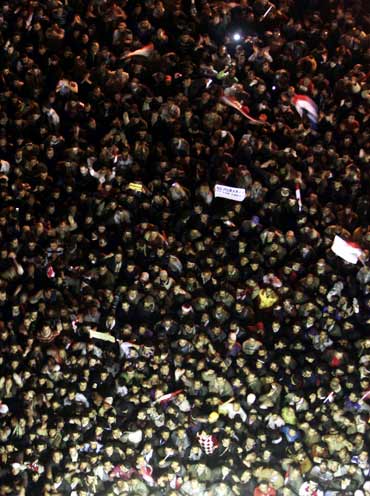Anti-government protesters in Cairo's Tahrir Square listen as President Hosni Mubarak speaks to the nation on Thursday