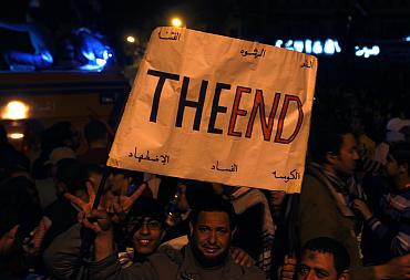 Anti-government protesters carry a placard and celebrate in Tahrir square in Cairo