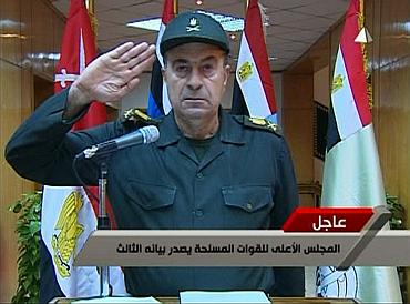 A spokesman for Egypt's higher military council salutes while reading a statement on transition of power