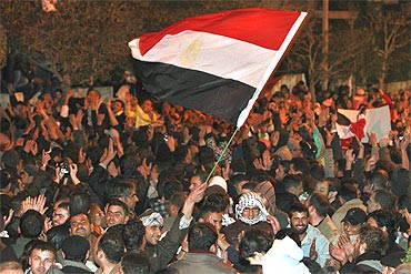 Protesters wave an Egyptian national flag as they celebrate after the announcement of President Hosni Mubarak's resignation on Friday
