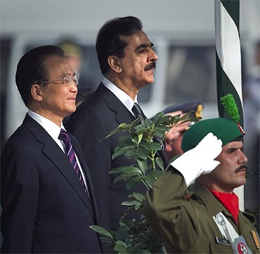 Pakistan Prime Minister Yousuf Raza Gilani and Chinese Premier Wen Jiabao listen to the national anthems of both countries during an official ceremony in Islamabad