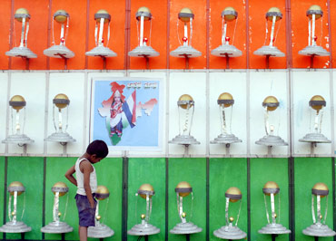 A child looks at models of the ICC Cricket World Cup trophy in Hyderabad. Artist T Vishnu built 51 models of the World Cup trophy, wishing the Indian team good luck.