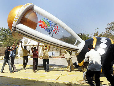 Workers erect an inflatable model of the 2011 Cricket World Cup trophy in Hyderabad