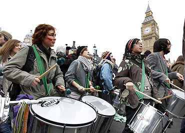 Demonstrators play drums during a march protesting the raising of student tuition fees in London