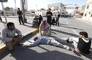 A protester collapses after inhaling tear gas during a demonstration in Manama