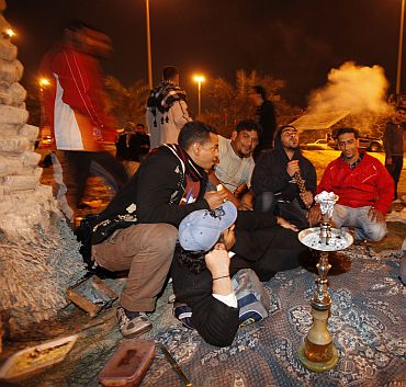 Hours before the riot police stepped in, protesters are seen sitting near a traditional Arabic shisha pipe as they camp out at the Pearl Roundabout