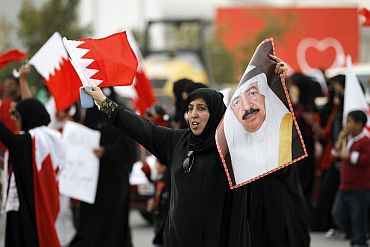 A Bahraini woman holds a picture of Prime Minister Prince Khalifa bin Isa al-Khalifa as she shouts pro-government slogans during a pro-government rally in Riffa
