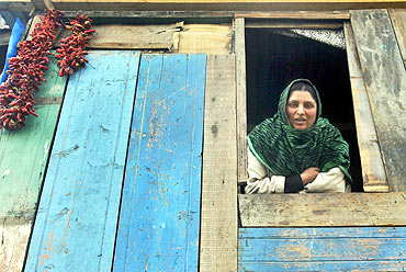 A Kashmiri woman at the window of her makeshift home on the banks of Jhelum river in Srinagar
