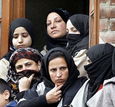Kashmiri women watch an Ashura procession in Srinagar