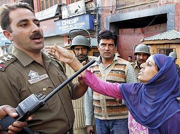 A Kashmiri woman pleads with a police officer to release her relative detained during an anti-India protest in Srinagar