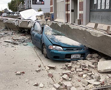 A car is crushed by fallen concrete after an earthquake in central Christchurch