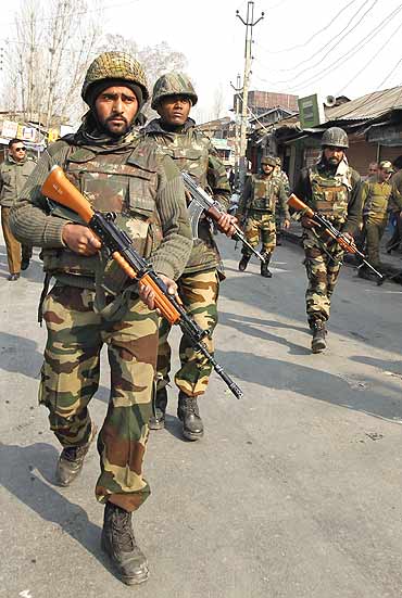 Army soldiers patrol the scene of a shootout in Srinagar
