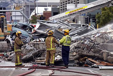 Firemen hose down the rubble of the CTV building which was devastated by a 6.3 magnitude earthquake in central Christchurch