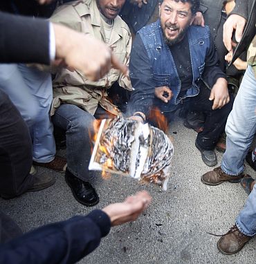 Protesters burn a copy of the Green Book written by Libyan leader Muammar Gaddafi as they chant anti-government slogans in the main square in Tobruk