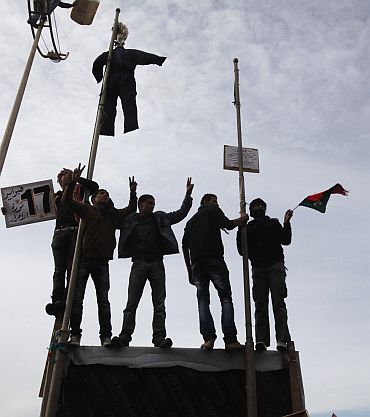 Protesters chant anti-government slogans while an effigy depicting Libyan leader Muammar Gaddafi is hung in a square in Benghazi city