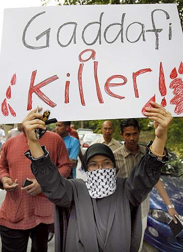 A protester holds a placard during a demonstration against Libya's leader Muammar Gaddafi