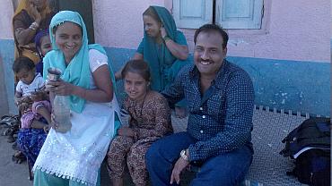 Sadiq with his wife and daughter outside their home