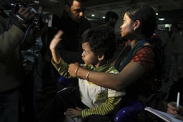 A boy gestures to a newsman upon his arrival at the airport in New Delhi from Libya